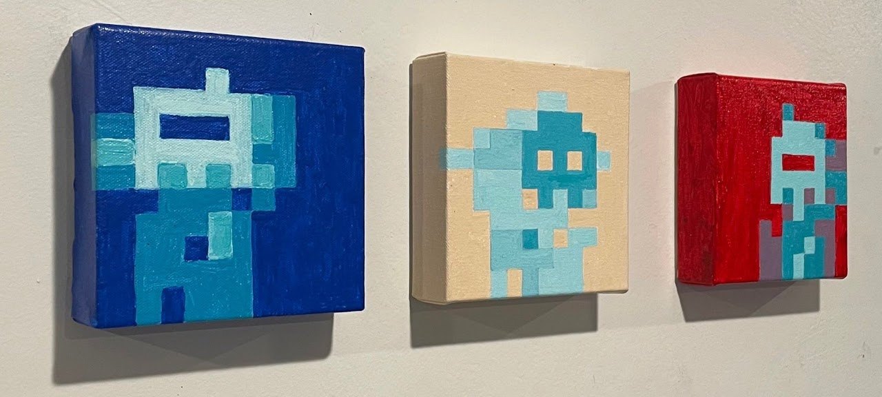 Three byteGANs painted on small square canvases, hung in a row